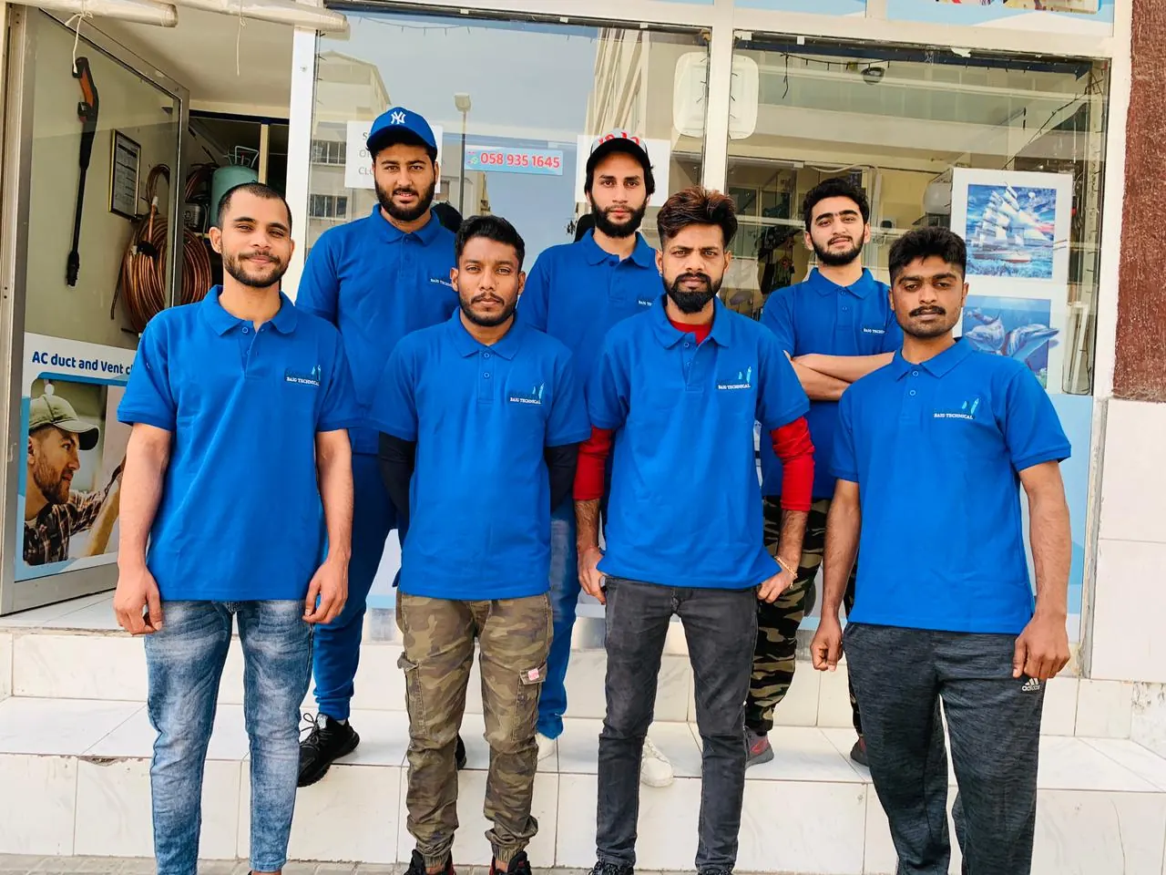 The Naseem Baig Technical Services team in uniform outside the Al Karama shop